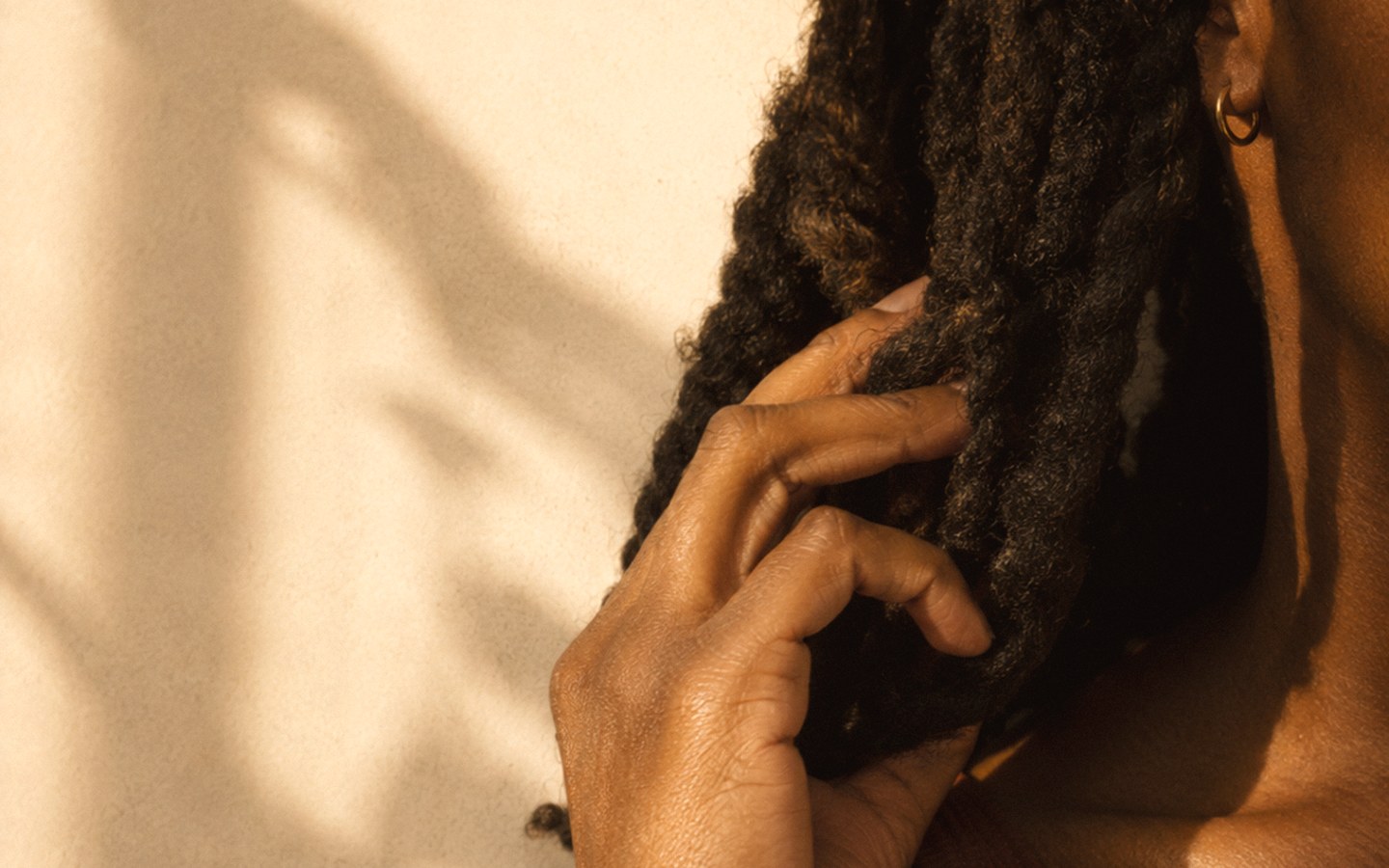 A person in a quiet, reflective moment, warm light on their hair