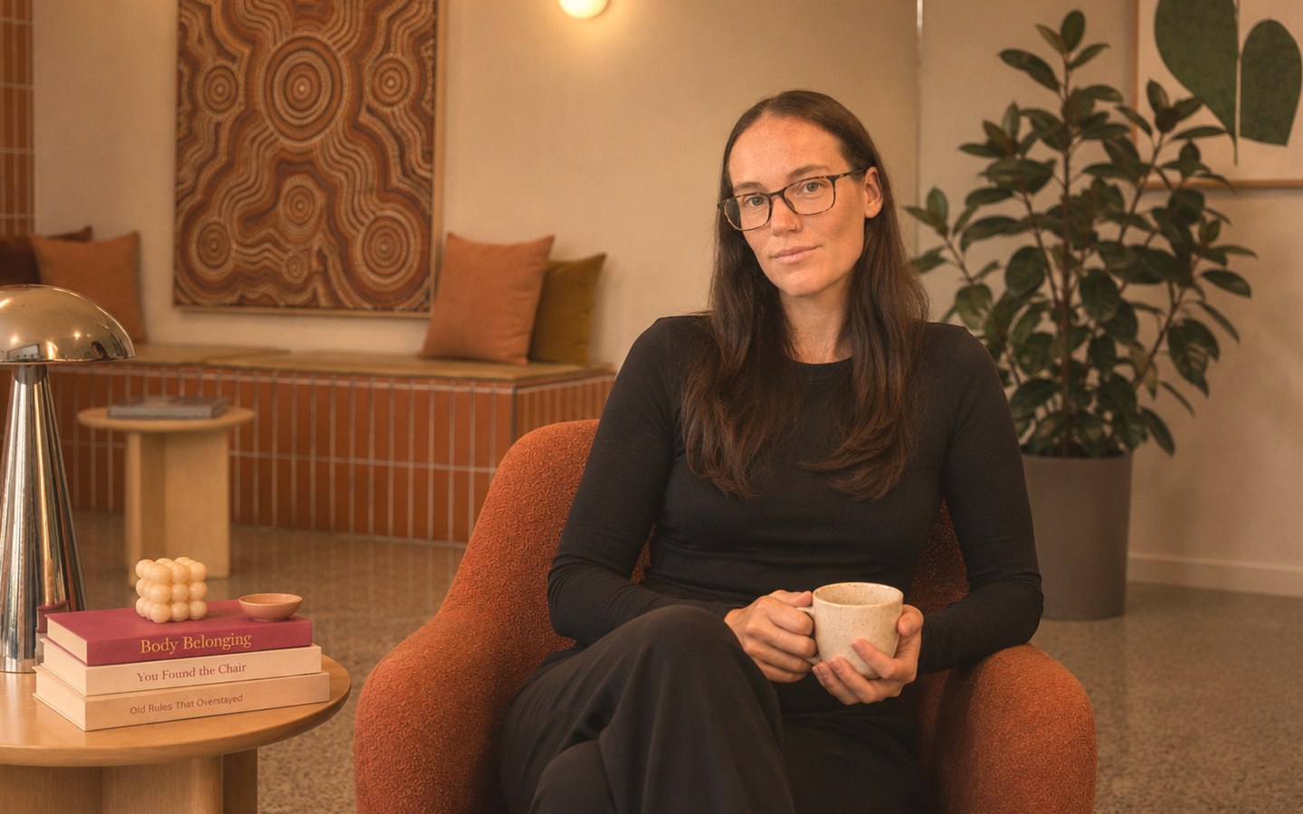 Lauren seated in the Body Belonging Clinic lounge room in Nedlands